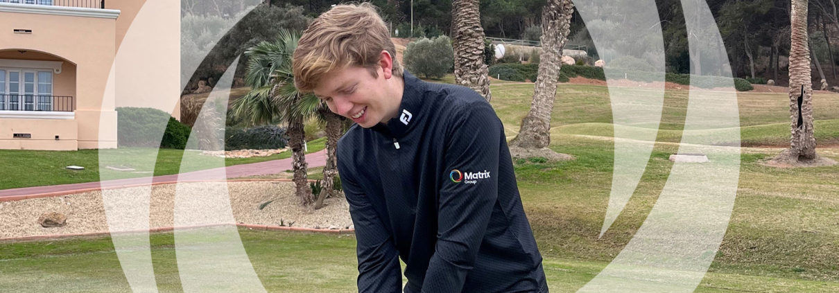Tom Hughes on the pitch in a Matrix Group branded black jumper.