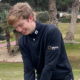 Tom Hughes on the pitch in a Matrix Group branded black jumper.